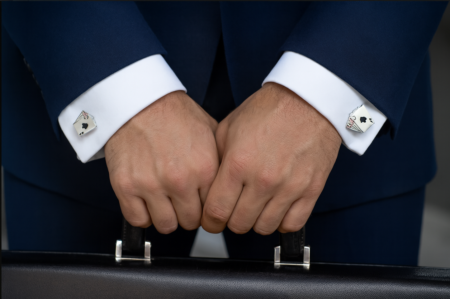 Four aces cufflinks on navy suit in business setting