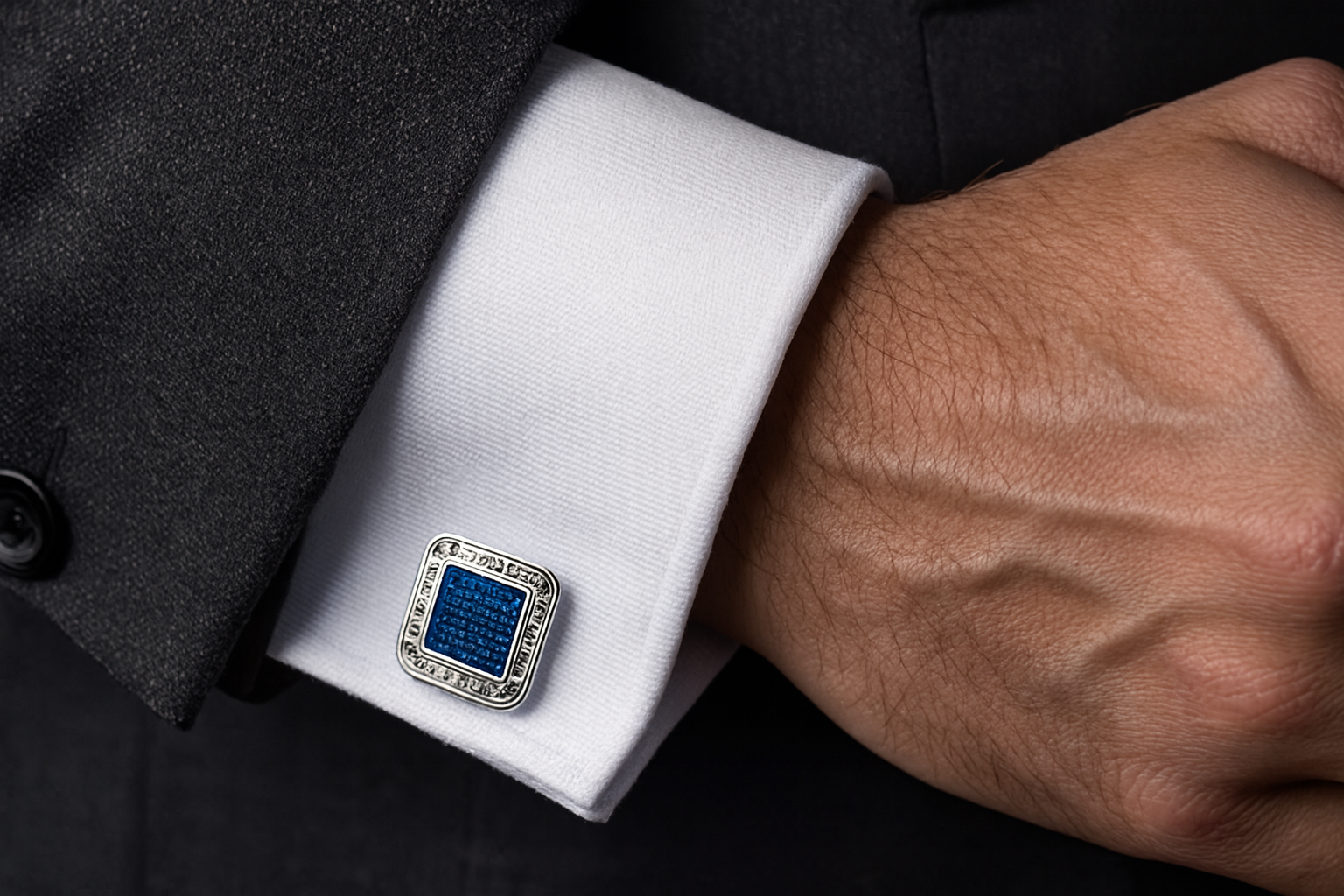 Close-up detail of Greek key cufflinks on formal suit cuff