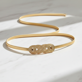 Elegant flat lay of gold chain belt on marble surface