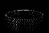 Multiple angles of the shiny black bracelet on black table