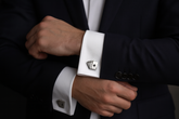Playing card cufflinks on navy suit with white dress shirt