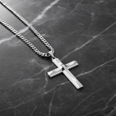 Silver cross necklace on dark marble